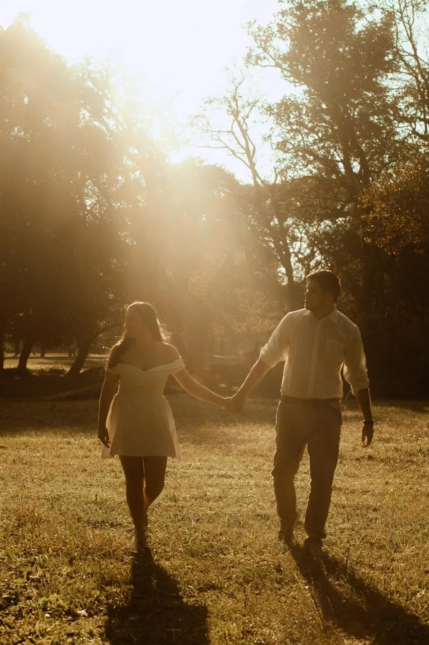 Marly y Marcos caminando de la mano a contraluz del atardecer